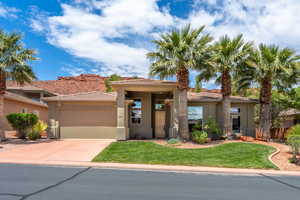 Prairie-style home with stucco siding, a garage, driveway, and a tile roof