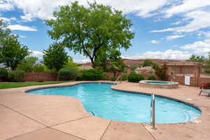 Community pool with a community hot tub, fence, and a patio area