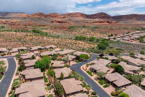 Aerial view of property and surrounding area with a mountainous background and nearby suburban area
