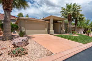 View of front of property with stucco siding, a garage, concrete driveway, and a tile roof