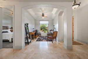 Office with ceiling fan, arched walkways, baseboards, and crown molding