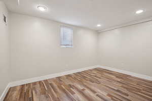 Basement with wood finished floors, recessed lighting, and baseboards