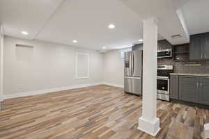 Kitchen with stainless steel appliances, gray cabinetry, light wood-style floors, baseboards, and recessed lighting