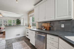 Kitchen featuring dishwasher, decorative backsplash, plenty of natural light, and a ceiling fan
