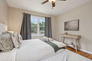 Bedroom with wood finished floors, baseboards, and ceiling fan