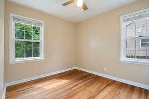 Spare room with baseboards, light wood-type flooring, and ceiling fan