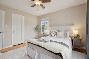 Bedroom featuring light wood-type flooring, baseboards, and a ceiling fan