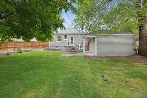 Back of property with a patio area and roof with shingles