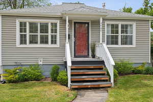 View of exterior entry with a yard