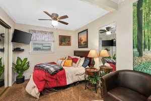 Carpeted bedroom featuring crown molding and ceiling fan