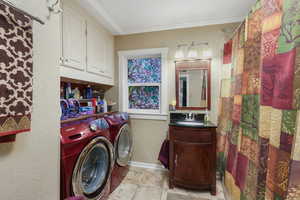 Washroom featuring separate washer and dryer, ornamental molding, and baseboards