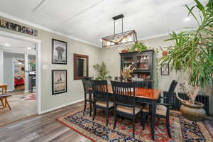 Dining area featuring baseboards, crown molding, and wood finished floors