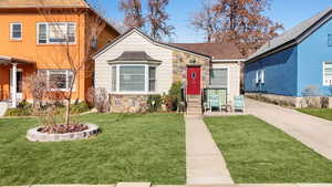 View of front of property with stone siding and a front yard