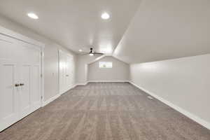 Additional living space with carpet floors, lofted ceiling, ceiling fan, baseboards, and recessed lighting
