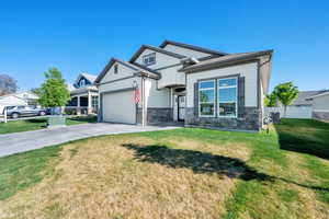Craftsman house featuring stone siding, driveway, a garage, and board and batten siding