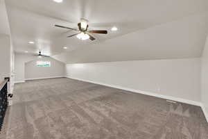 Additional living space with a ceiling fan, carpet flooring, vaulted ceiling, baseboards, and recessed lighting