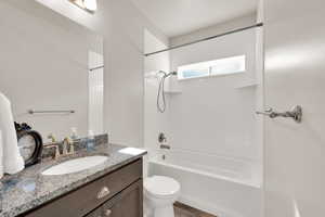 Full bathroom featuring toilet, bathtub / shower combination, and vanity