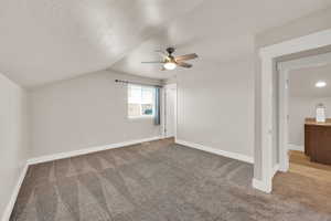 Bonus room with a ceiling fan, carpet floors, baseboards, and vaulted ceiling