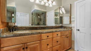 Bathroom with a stall shower, double vanity, and tile patterned floors