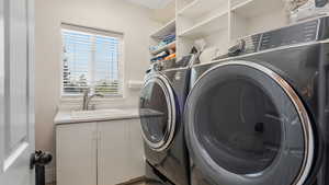 Washroom featuring a sink and separate washer and dryer