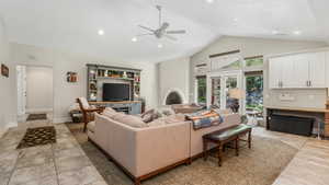 Living area with ceiling fan, high vaulted ceiling, recessed lighting, light tile patterned floors, and baseboards