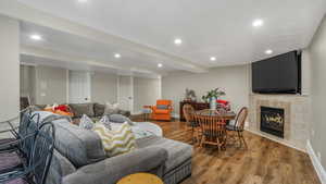 Living room with wood finished floors, recessed lighting, baseboards, and a tile fireplace