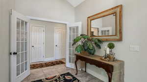 Entryway with french doors, high vaulted ceiling, and baseboards