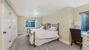 Bedroom with light colored carpet, baseboards, and a closet