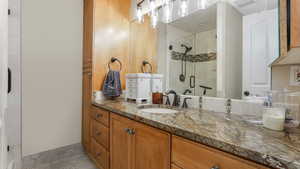 Full bathroom featuring a shower stall, tile patterned flooring, and vanity