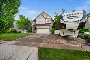 Traditional-style house with concrete driveway, a garage, and stucco siding