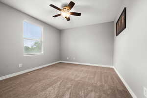 Unfurnished room with carpet floors, ceiling fan, and baseboards
