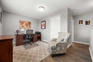 Home office/flex space featuring baseboards and wood finished floors