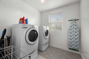 Laundry room featuring washer and dryer and baseboards