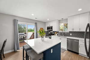 Kitchen featuring appliances with stainless steel finishes, a sink, healthy amount of natural light, backsplash, and recessed lighting