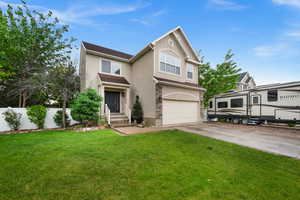 Traditional-style home with stucco siding, an attached garage, concrete driveway, and stone siding