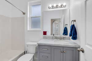 Full bath with toilet, vanity, and bathing tub / shower combination