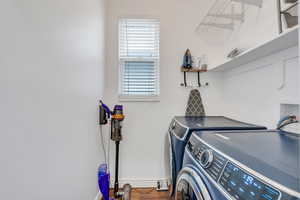 Laundry room featuring independent washer and dryer, baseboards, and wood finished floors