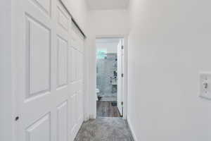 Hallway featuring carpet floors and tile walls