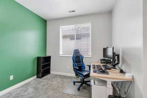 Carpeted office space with baseboards