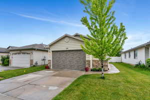 Single story home featuring concrete driveway, brick siding, and an attached garage