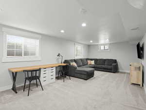 Living area featuring light carpet, recessed lighting, and baseboards