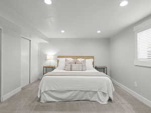 Bedroom with recessed lighting, light colored carpet, baseboards, and a closet