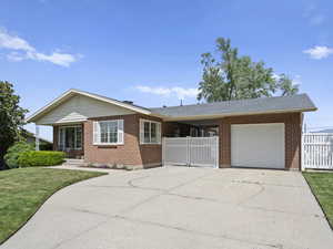 Ranch-style house featuring brick siding, an attached garage, and concrete driveway