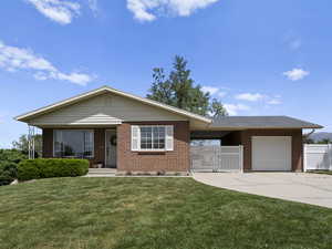 Ranch-style house featuring concrete driveway, brick siding, and an attached garage