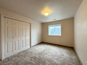 Unfurnished bedroom featuring carpet floors, a closet, and baseboards