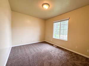 Carpeted spare room with baseboards