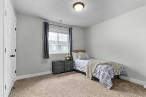 Bedroom with light colored carpet and baseboards