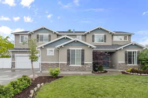 Craftsman house with stucco siding, driveway, a garage, stone siding, and a shingled roof