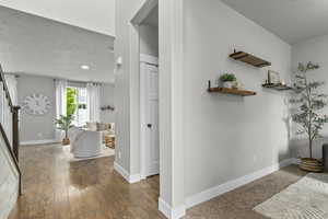 Entrance foyer with stairway, baseboards, dark wood-style flooring, and recessed lighting