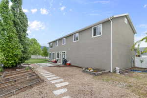 Rear view of property featuring fence, stucco siding, and a patio